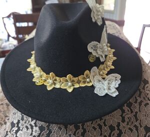 Elegant Black Hat with Gold and White Floral Accents